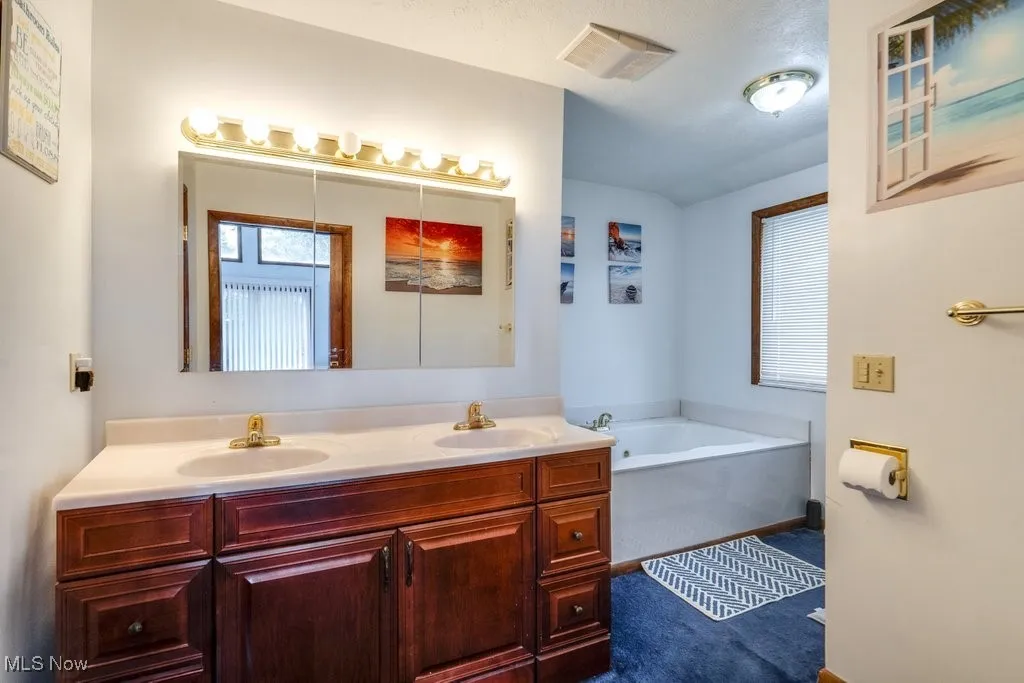 Bathroom featuring double vanity and a garden tub