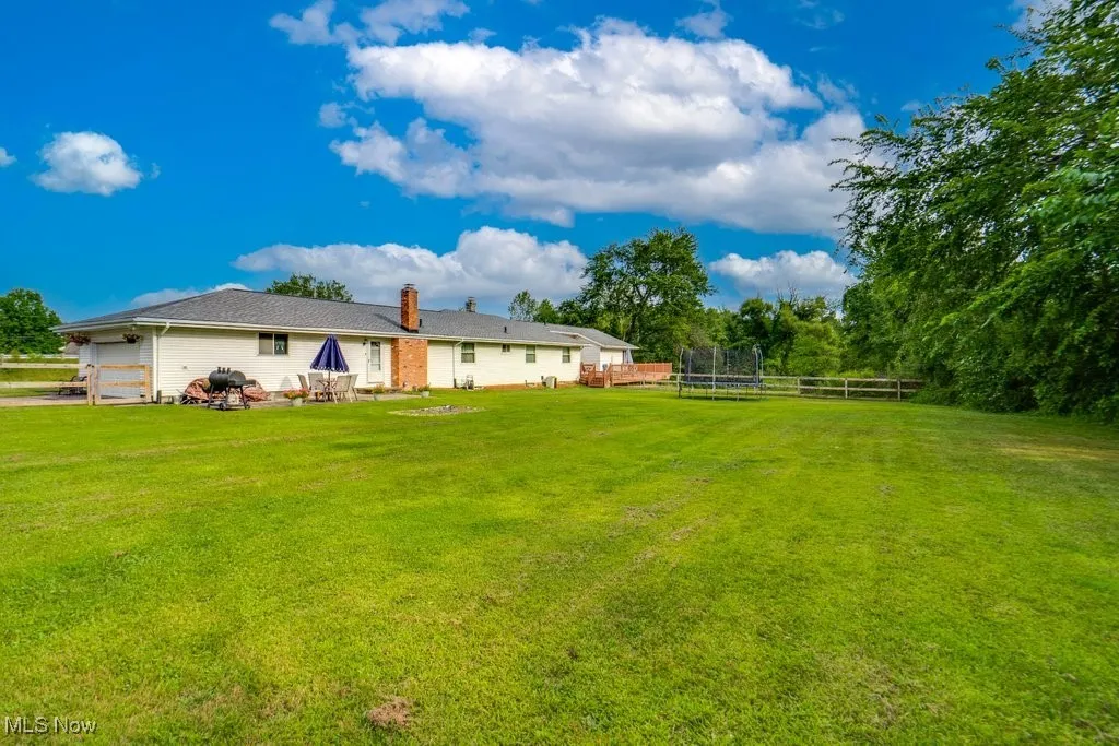 Rear view of house with a trampoline and a chimney