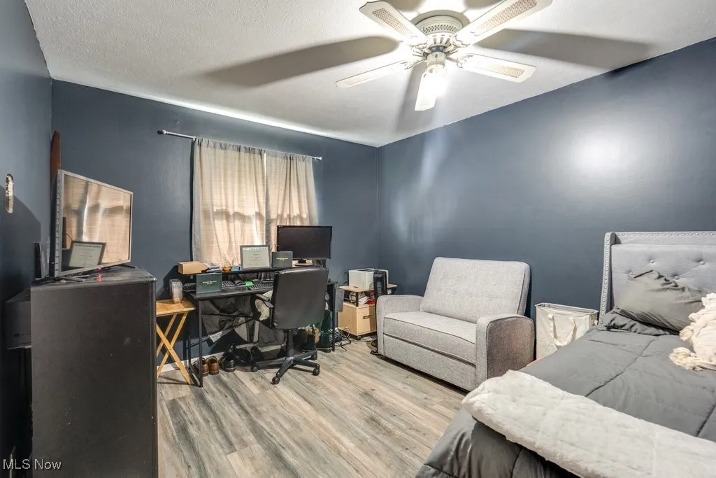 Office space featuring a textured ceiling, wood finished floors, and ceiling fan