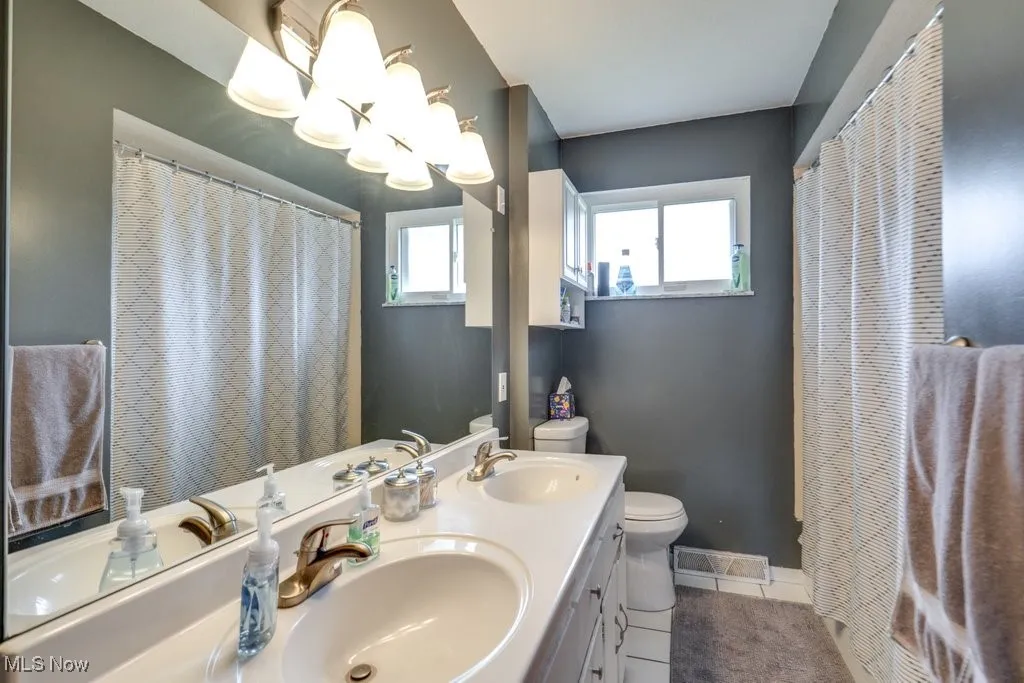 Bathroom with double vanity and tile patterned floors