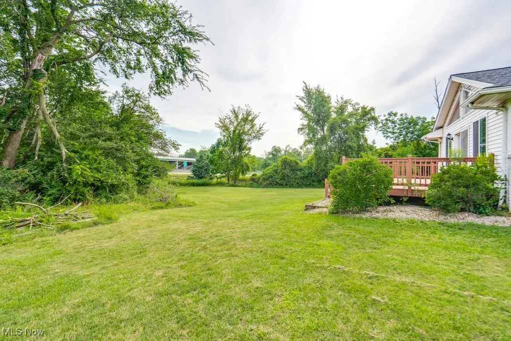 View of green lawn featuring a deck