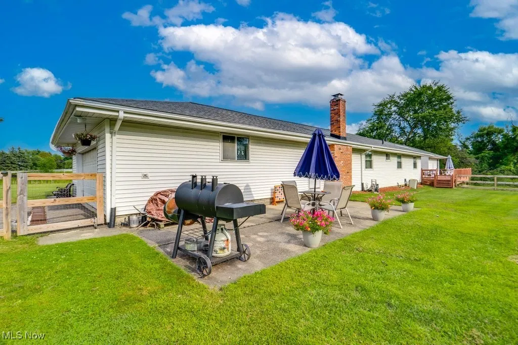 Rear view of house with a patio area, a wooden deck, and a chimney