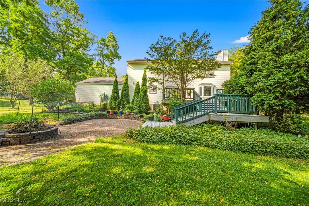 Rear view of house featuring a wooden deck & fireplace area