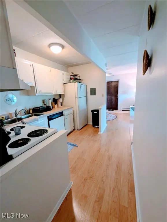 Kitchen featuring range hood, white cabinets, beamed ceiling, light wood-style floors, and light countertops