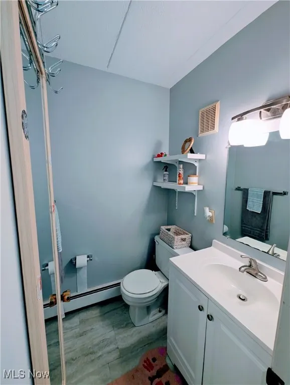 Bathroom with a baseboard heating unit and vanity