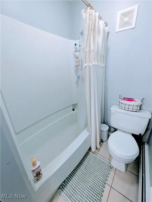 Bathroom with tile patterned floors and shower / tub combo