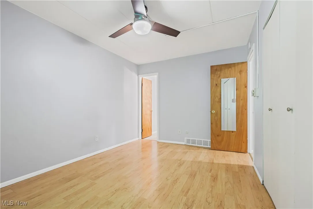 Unfurnished bedroom with wood finished floors and a ceiling fan