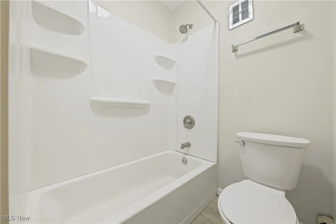 Full bath featuring toilet and shower / washtub combination