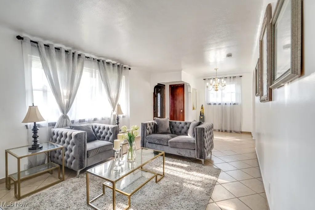 Living area with light tile patterned floors and a chandelier