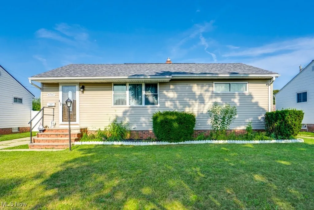 View of front of house featuring a front yard and a shingled roof