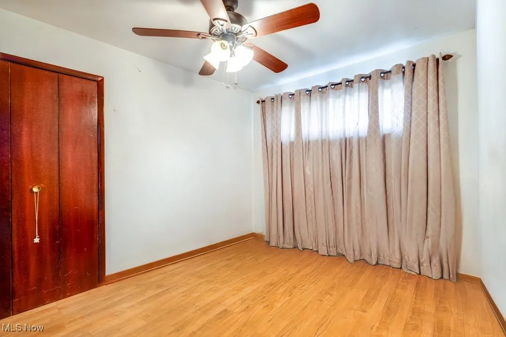 Empty room featuring light wood-type flooring and ceiling fan