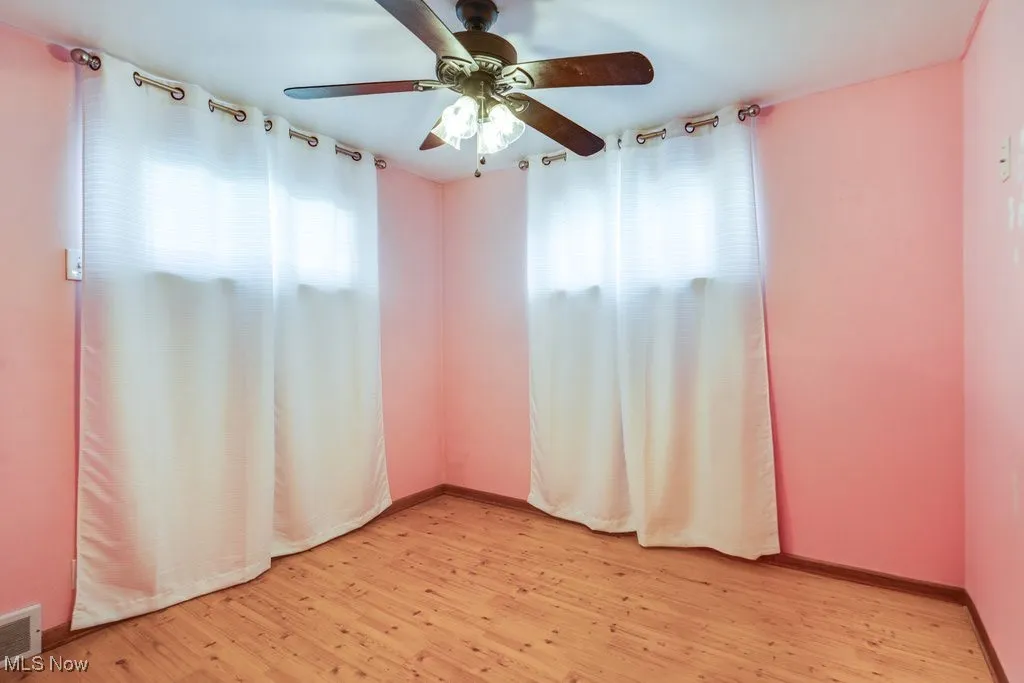 Empty room featuring light wood-type flooring and ceiling fan