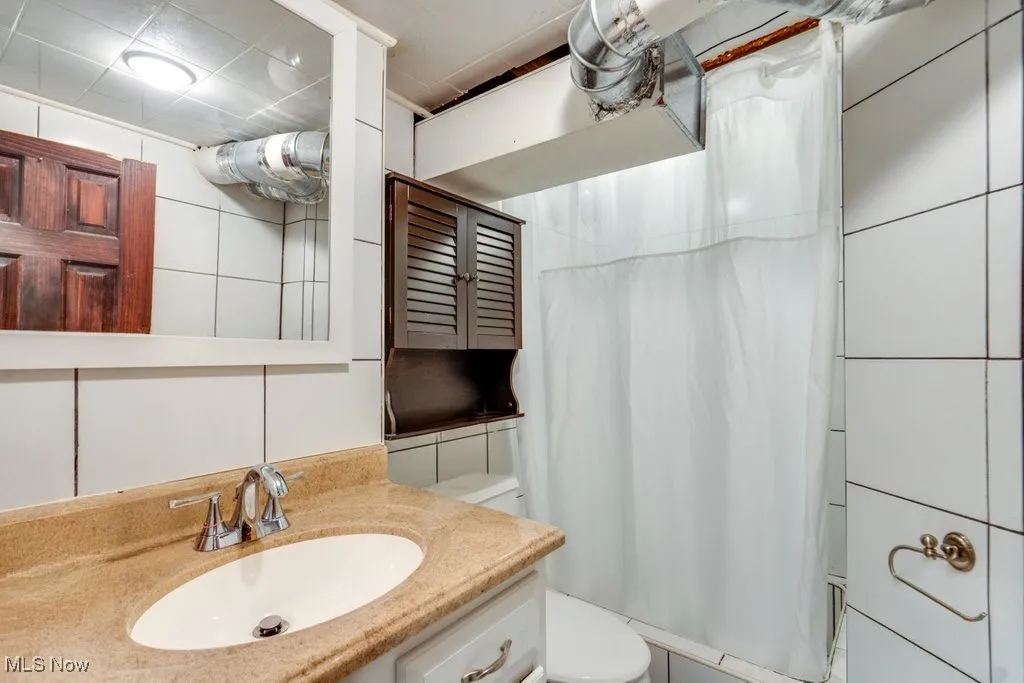 Full bath featuring vanity and curtained shower