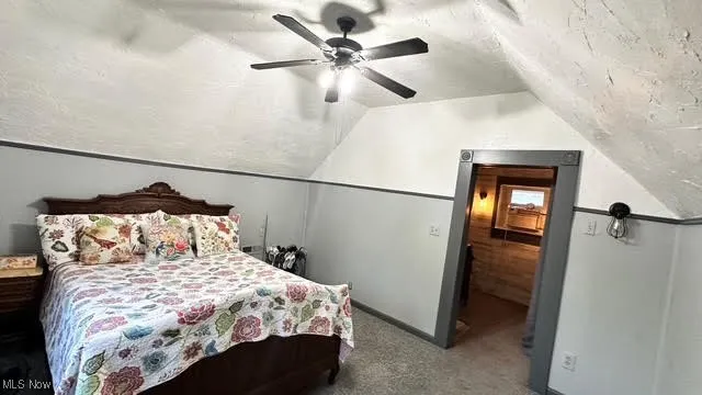 Second floor Bedroom featuring carpet, vaulted ceiling, a textured ceiling, and a ceiling fan
