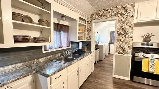 Kitchen with open shelves, stainless steel range with gas stovetop, a textured ceiling, and white cabinetry