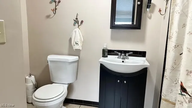 Full bathroom with vanity, tile patterned flooring, and shower