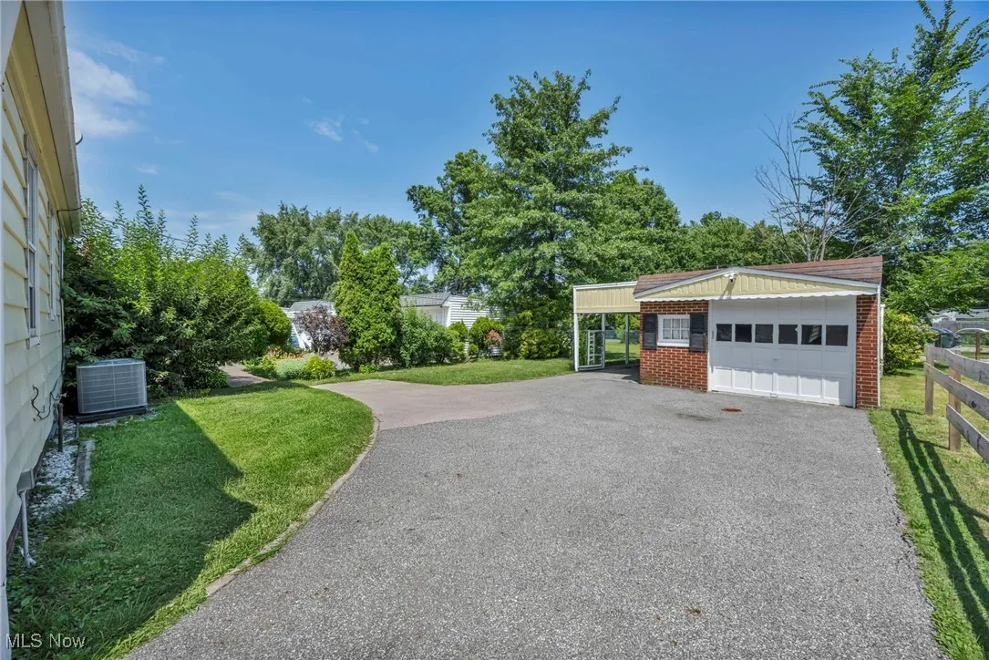 View of home's community with driveway, an outbuilding, and a garage