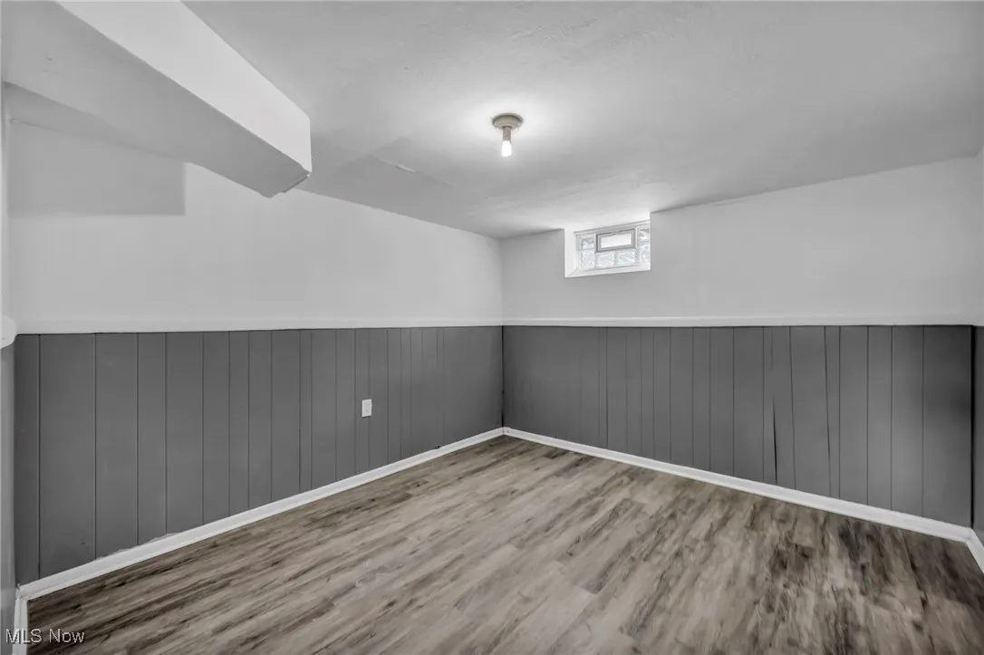 Below grade area featuring wainscoting and wood finished floors