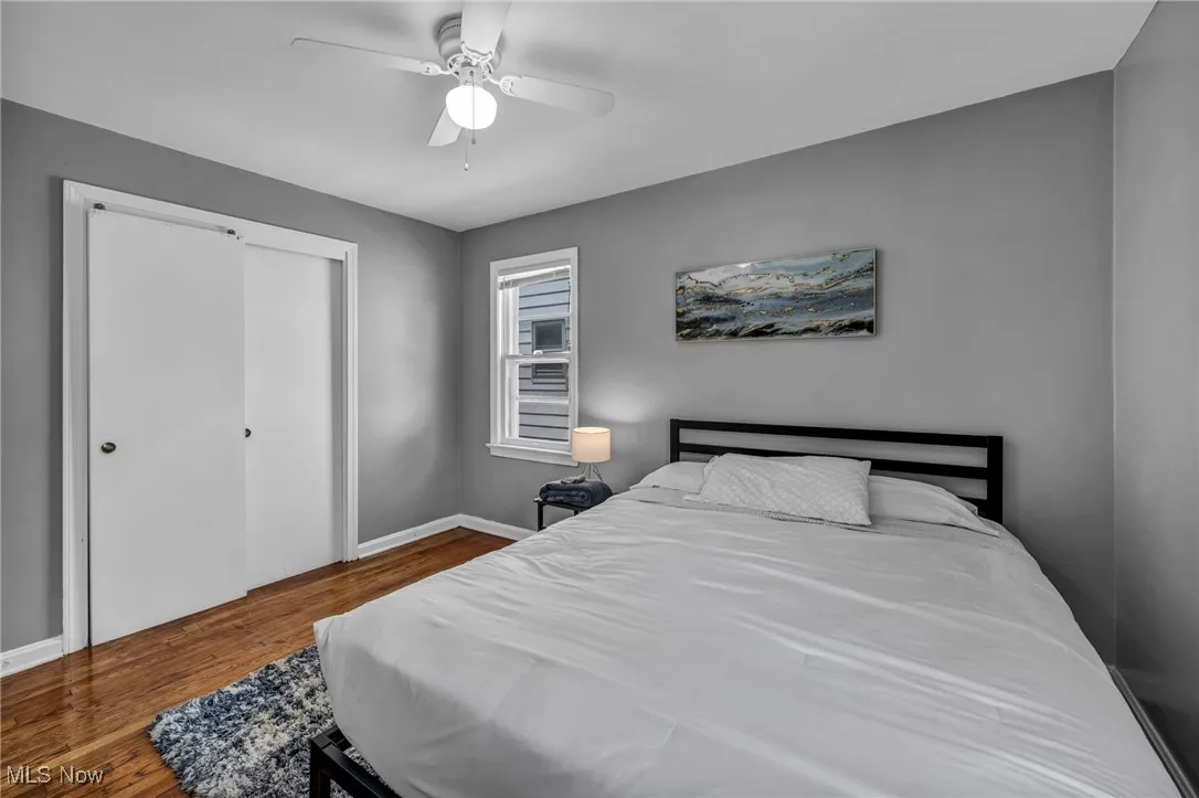 Bedroom with wood finished floors, a ceiling fan, and a closet