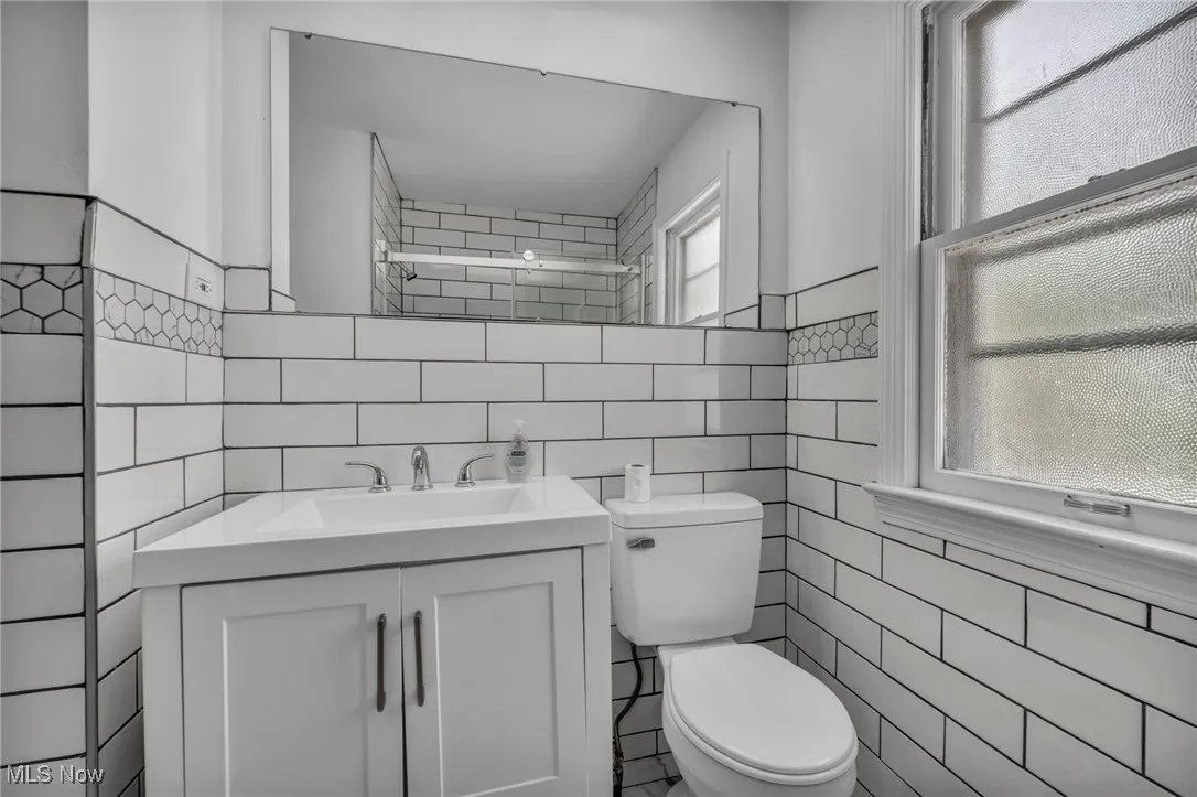 Bathroom with tile walls and vanity