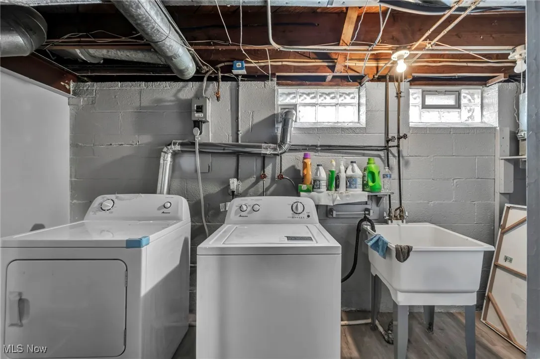Laundry room featuring separate washer and dryer and wood finished floors