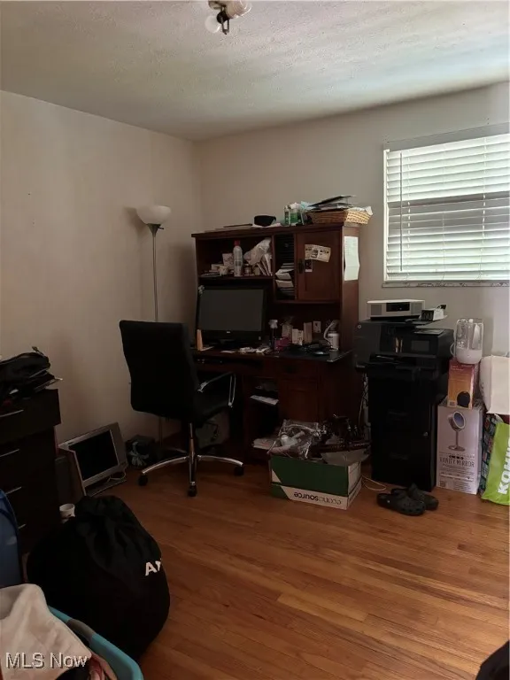 Office space featuring wood finished floors and a textured ceiling