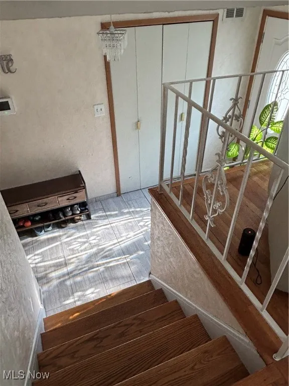 Staircase featuring a chandelier