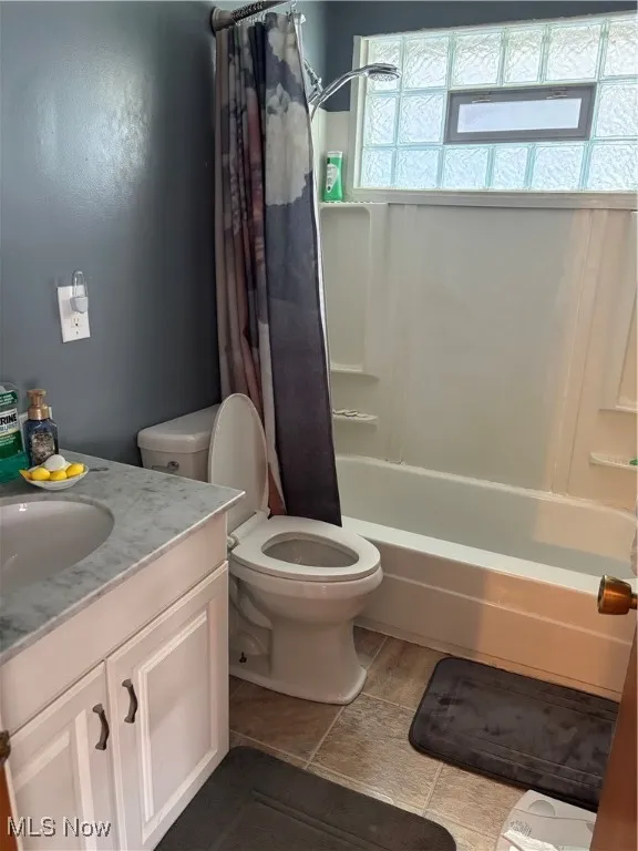 Full bathroom featuring vanity and shower / bath combination with curtain