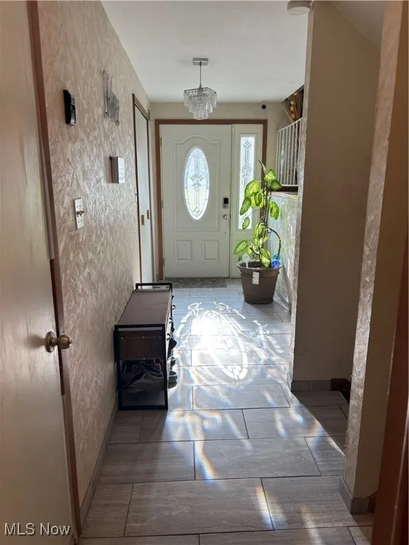 Foyer entrance with baseboards and a chandelier
