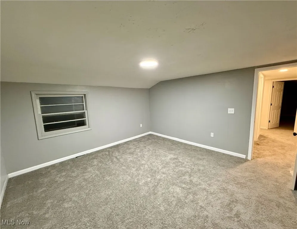 Carpeted spare room with baseboards