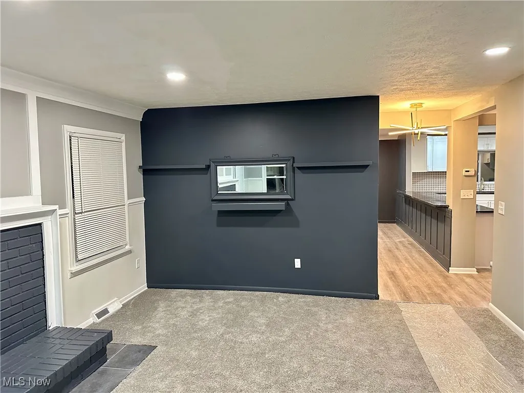 Kitchen with light carpet, recessed lighting, and a textured ceiling