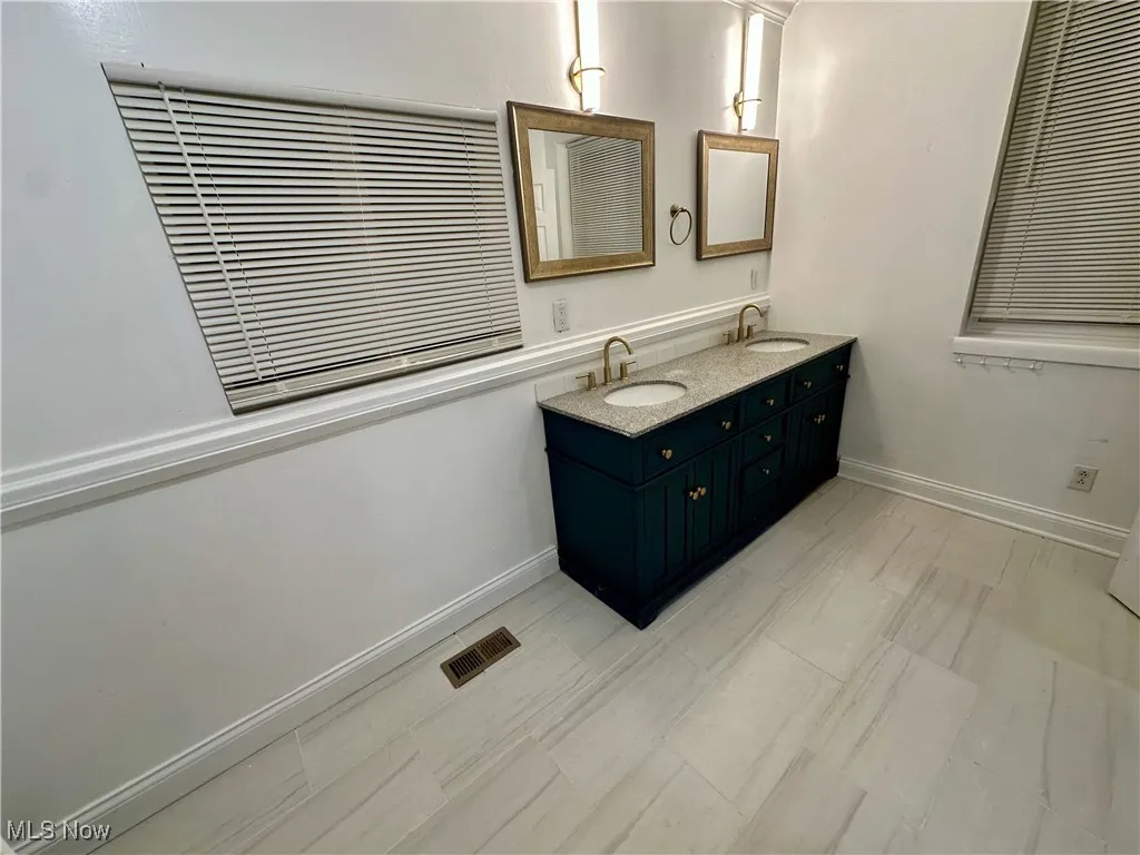 Bathroom featuring double vanity and baseboards