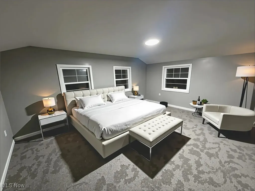 Bedroom with lofted ceiling and carpet