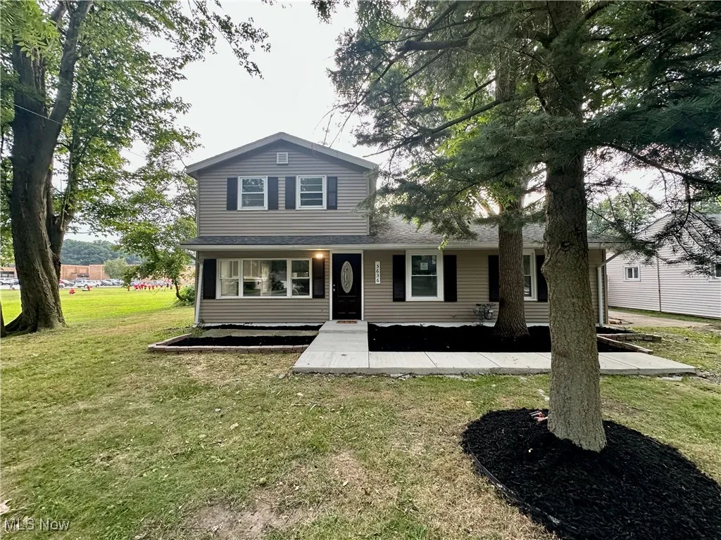 Traditional home featuring a front yard and a porch