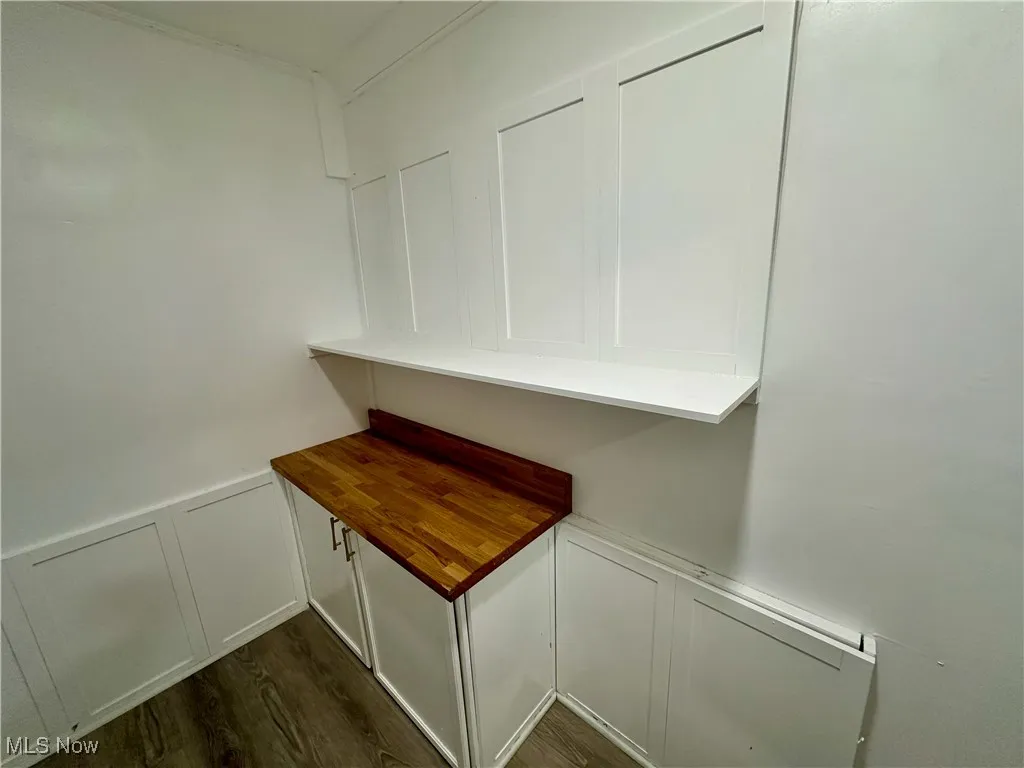Detailed view of a decorative wall, wainscoting, and wood finished floors