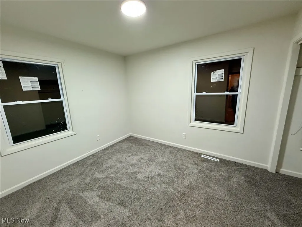 Empty room with carpet and baseboards