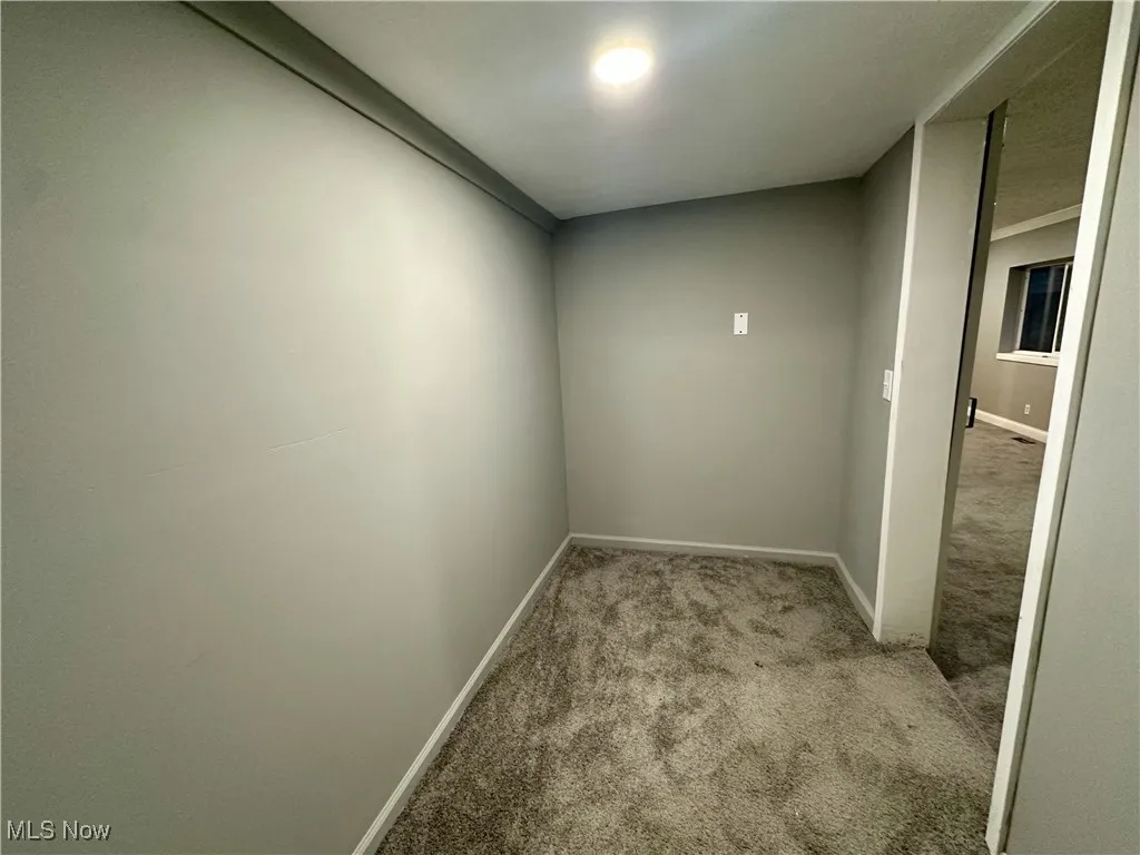 Carpeted empty room with baseboards