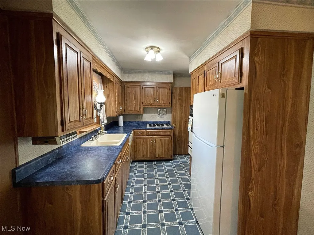 Galley kitchen with loads of cabinets for storage, and all of the appliances.