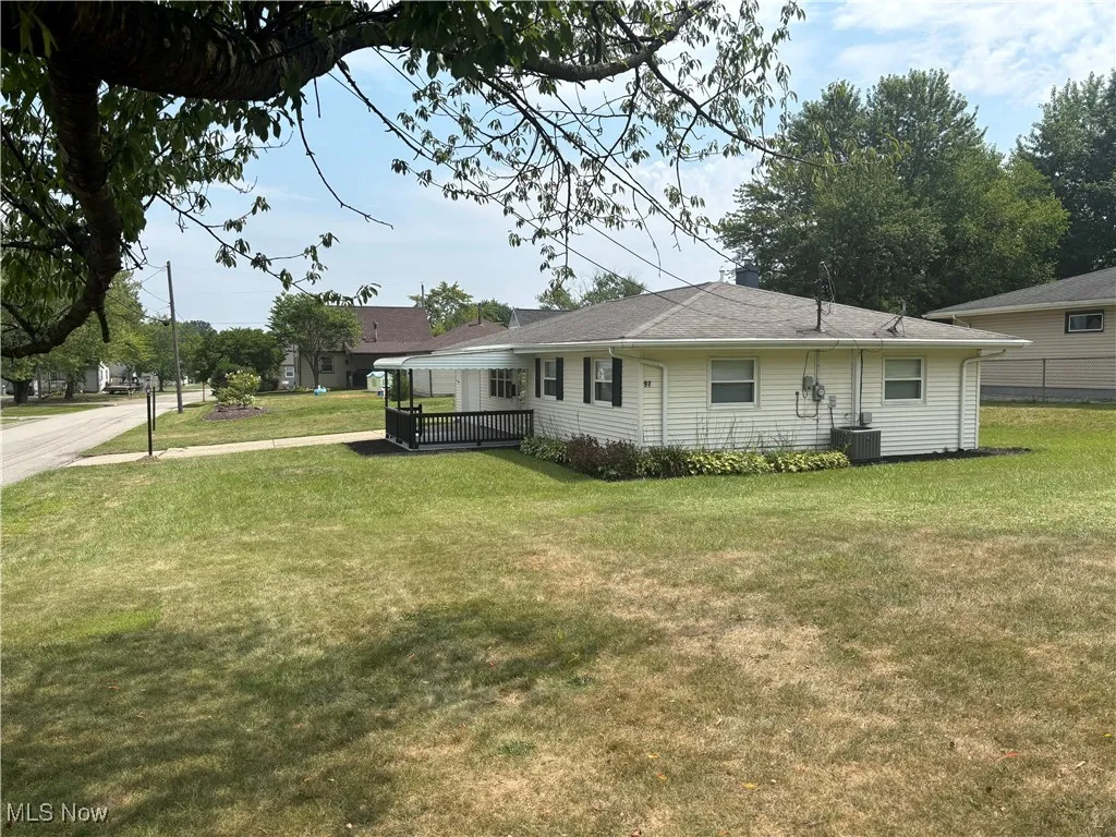 Rear view of property featuring a lawn and a wooden deck