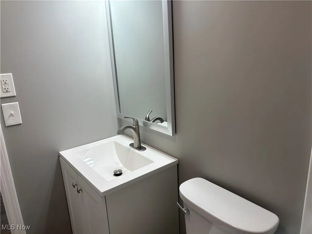 Half bathroom featuring vanity and toilet
