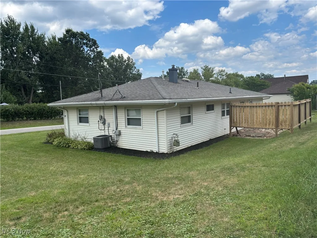 Back of property with a chimney and a shingled roof