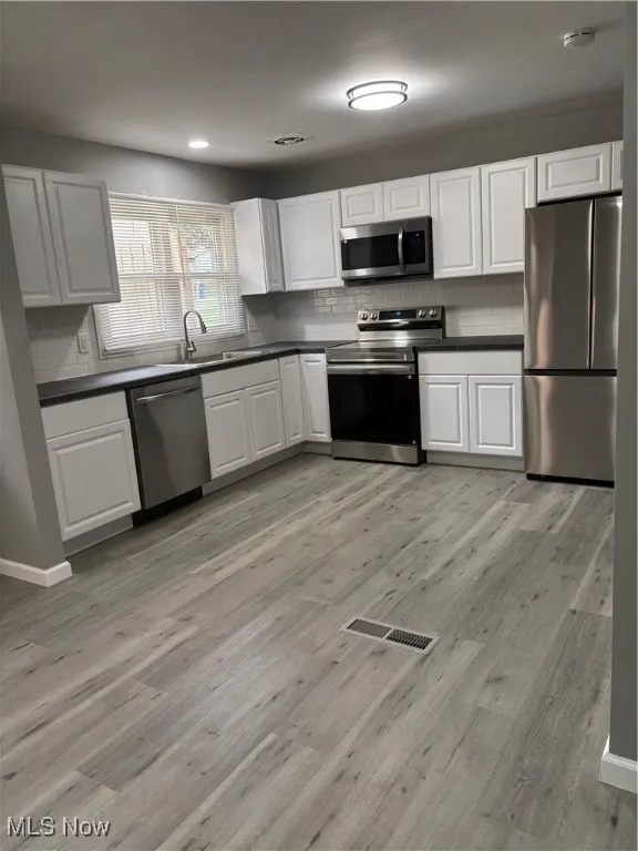 Kitchen featuring range, fridge, dark countertops, and recessed lighting