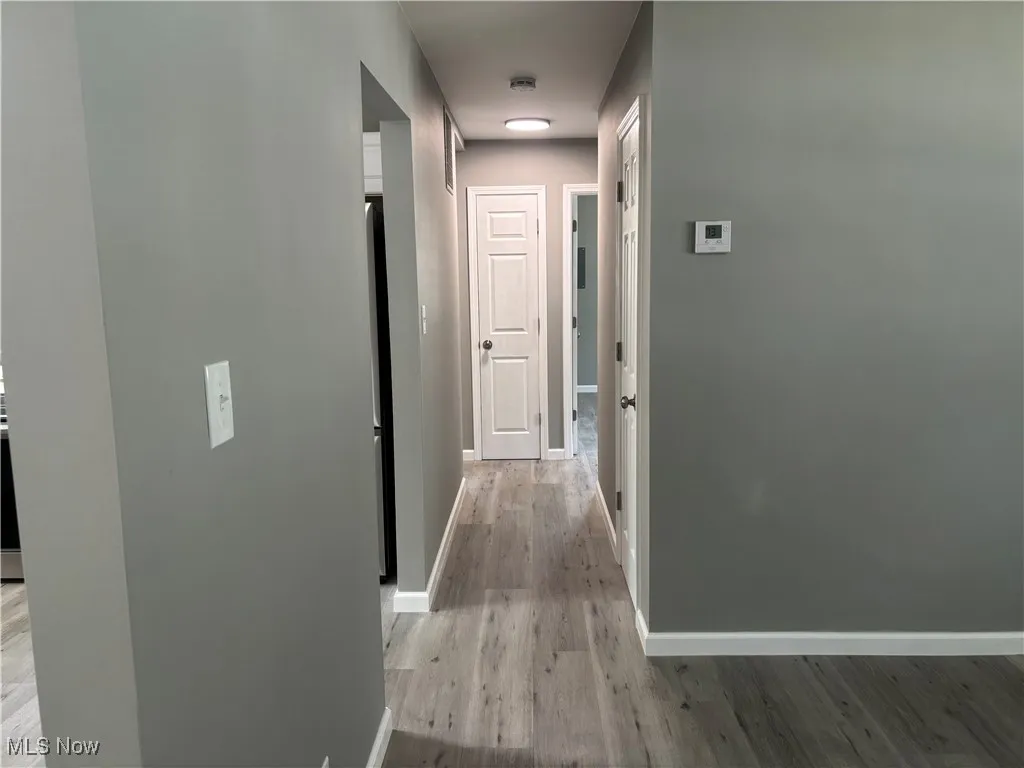 Hallway featuring baseboards and light wood-style floors
