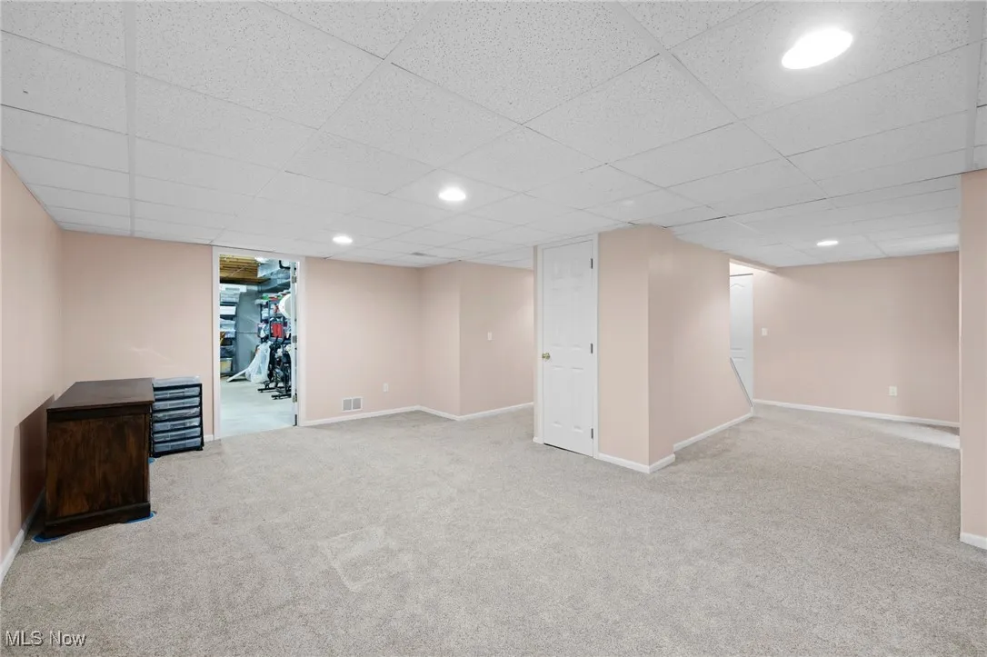 Finished basement featuring recessed lighting, carpet flooring, and a drop ceiling