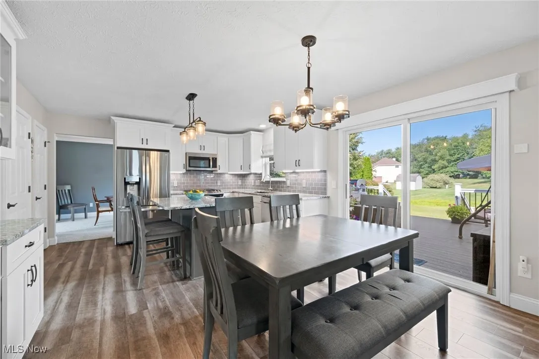 Dining area featuring a chandelier, dark wood finished floors, and a textured ceiling