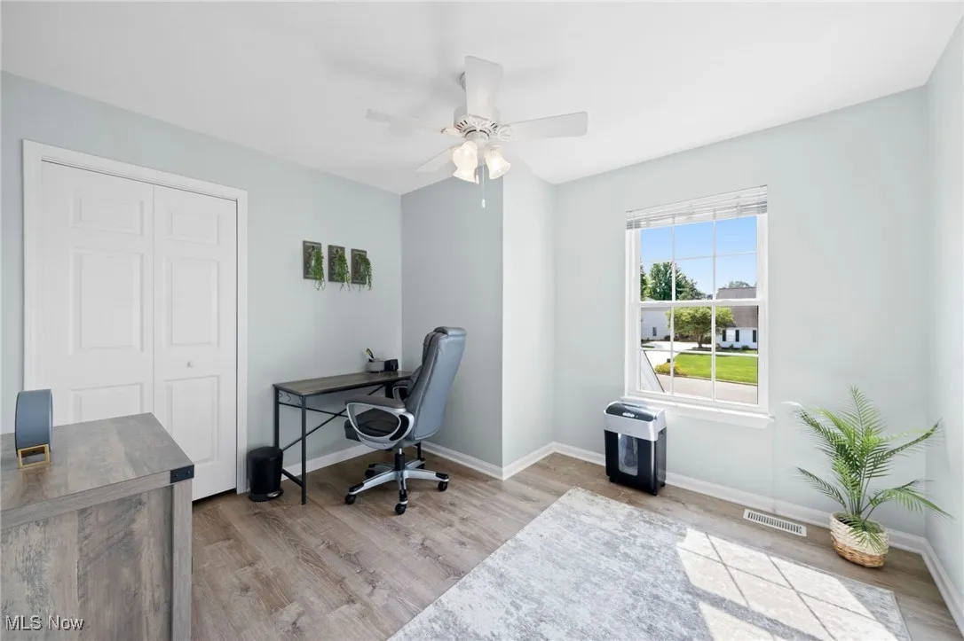 Bedroom #3 - currently being used and an office area with light LVTflooring and ceiling fan