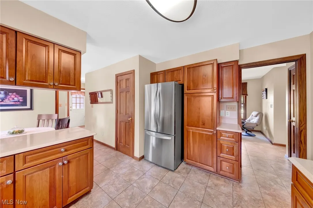 Kitchen flows into Family Room. Pantry door can be seen to the left of refrigerator. Cabinet pantry can be seen at right.