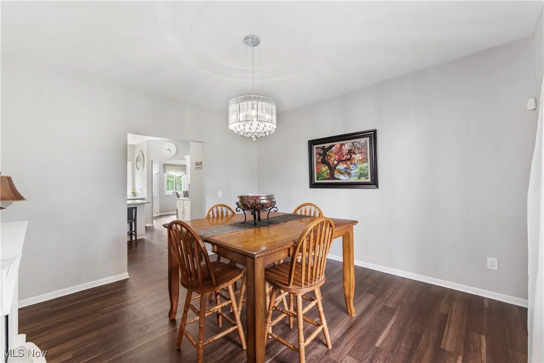 Dining space with dark wood-type flooring and a chandelier