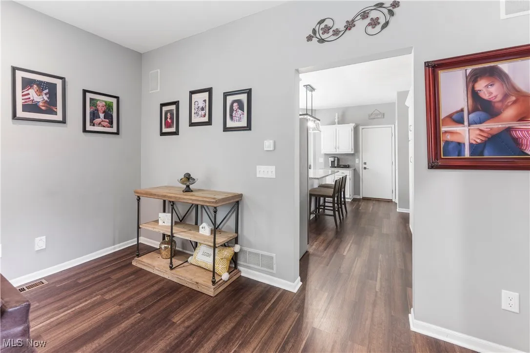 Corridor featuring dark wood-style floors and baseboards