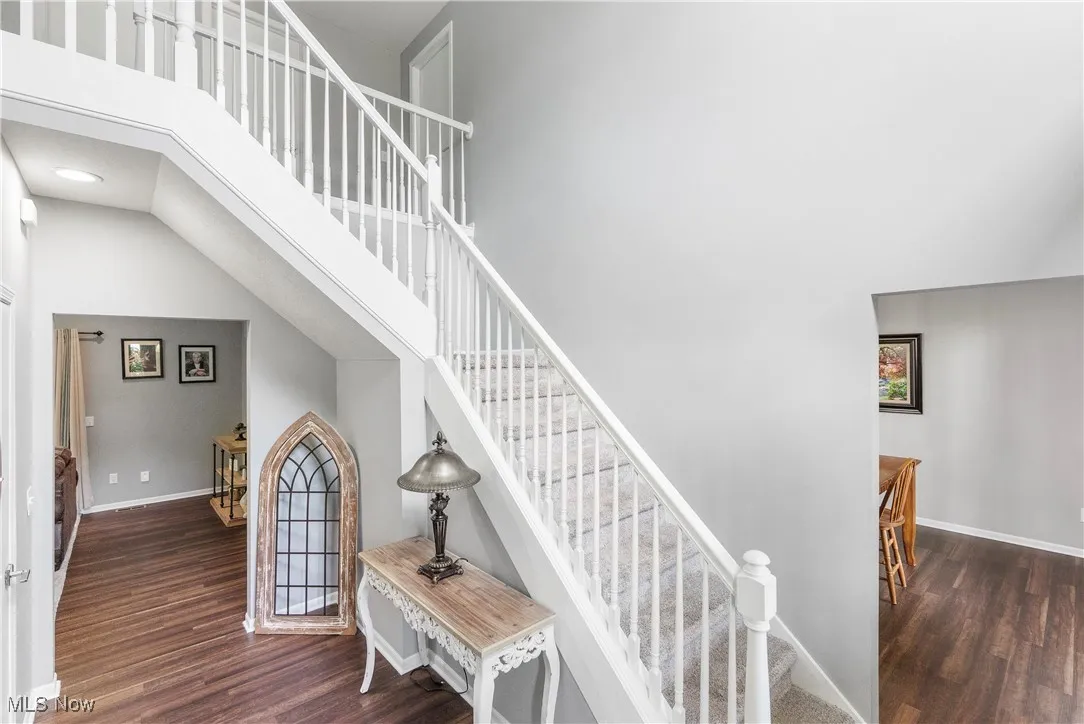 Stairs featuring wood finished floors and a high ceiling
